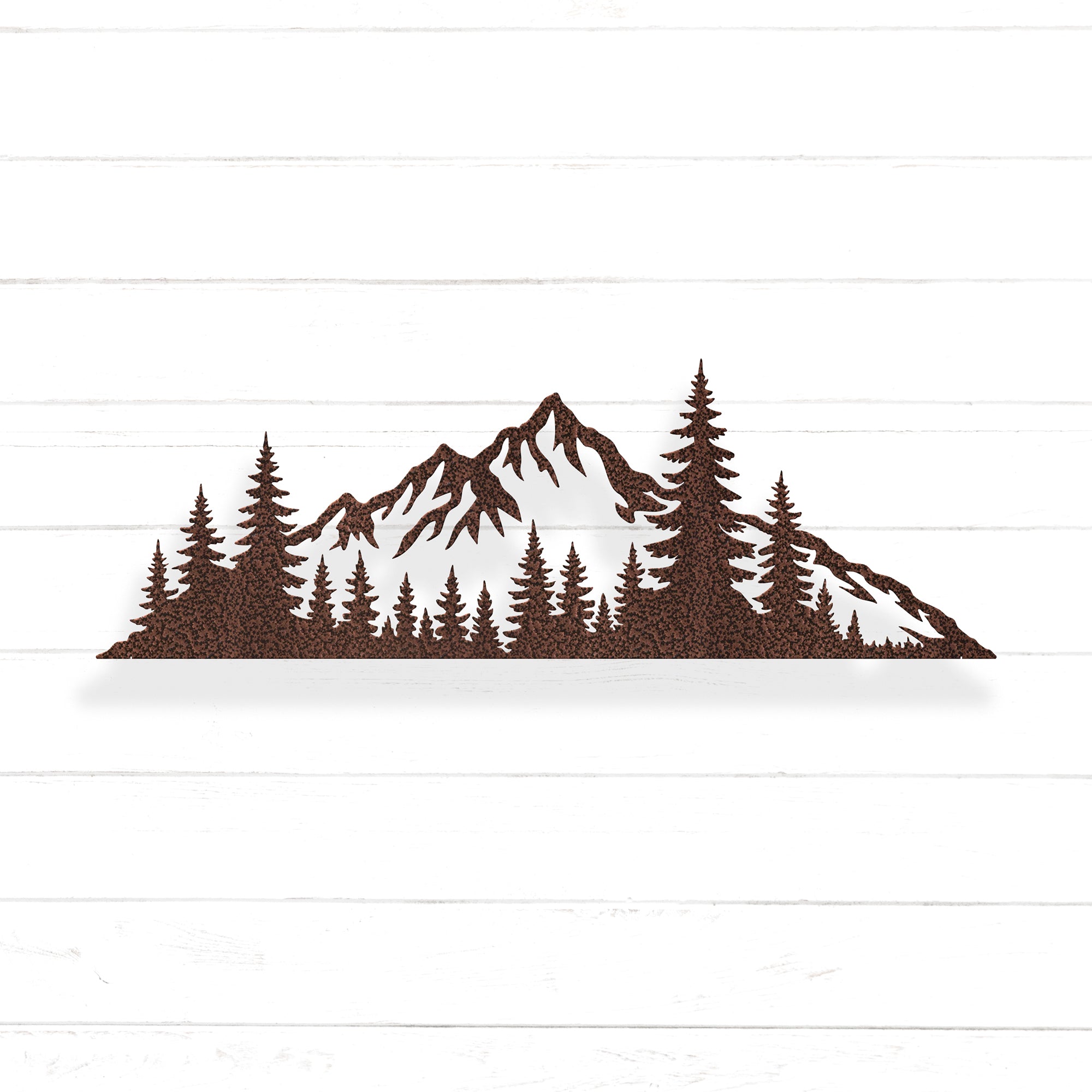A silhouette of a mountain range with pine trees in the foreground.