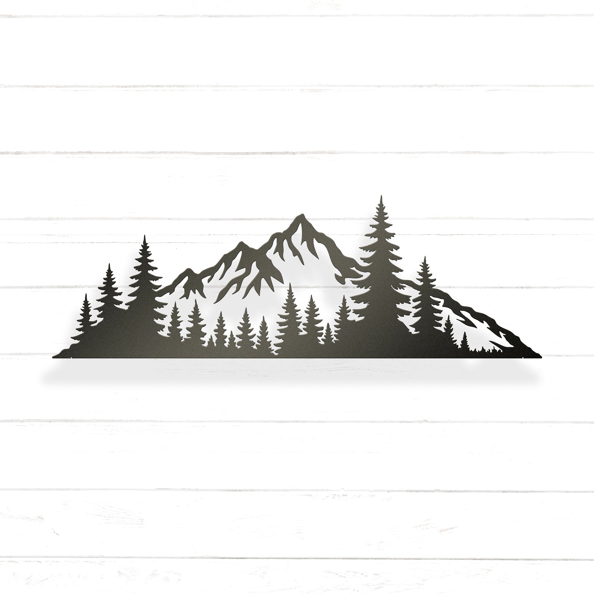 A silhouette of a mountain range with pine trees in the foreground.