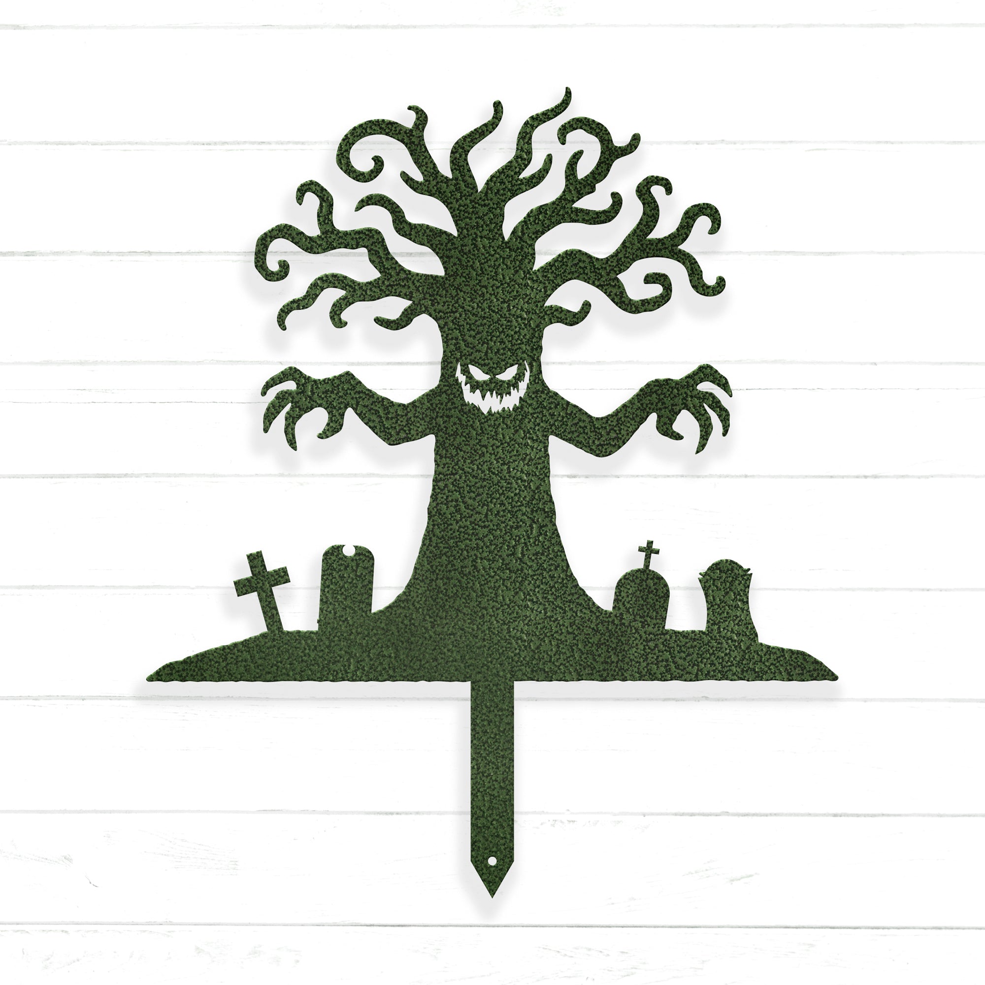 A silhouette of a tree with a face and hands, surrounded by cemetery-like elements such as crosses and gravestones.