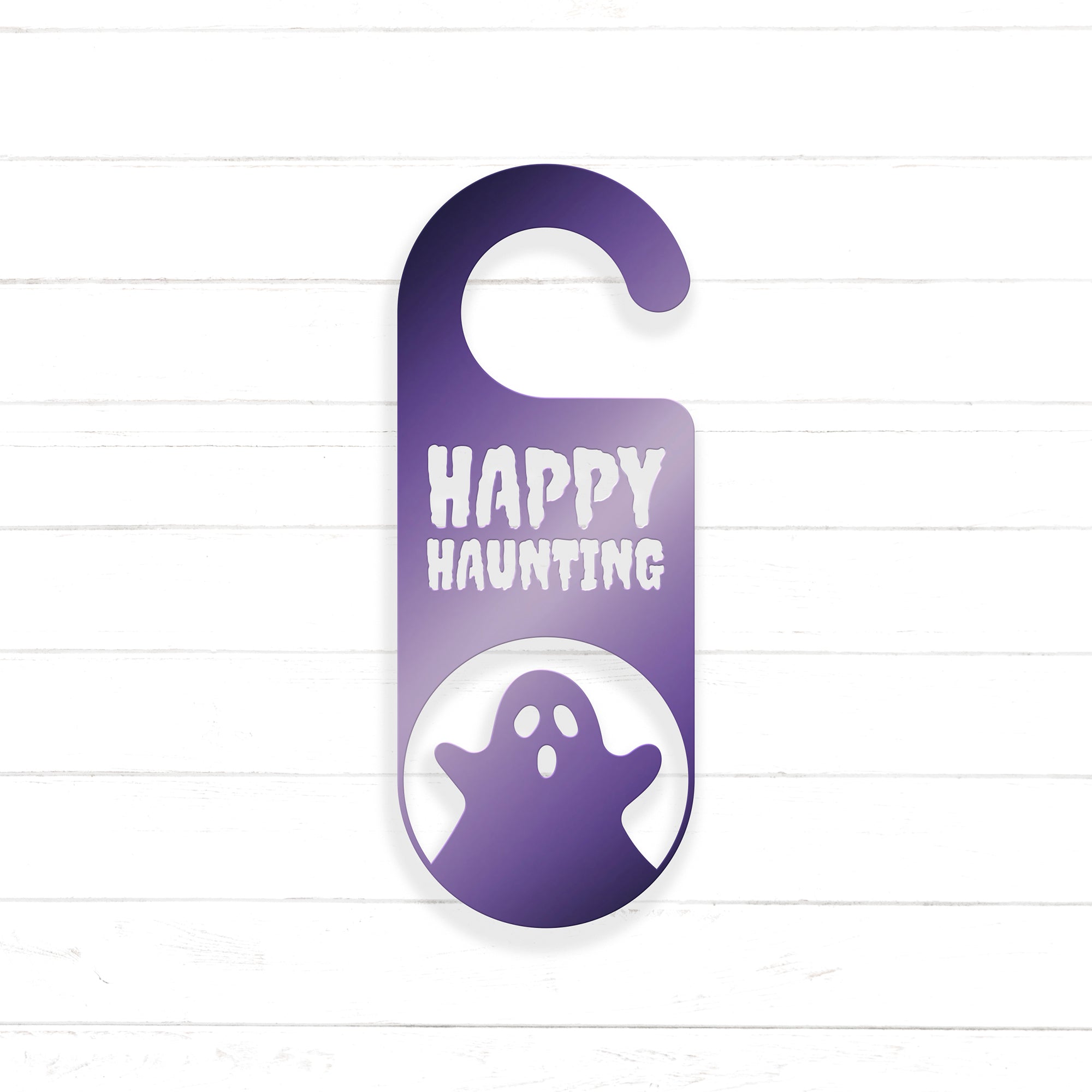A purple door hanger with the text "HAPPY HAUNTING" printed on it, along with a ghost silhouette.