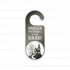 A black and white door hanger with a castle silhouette and the text "KNOCK FOR CANDY... IF YOU DARE!"