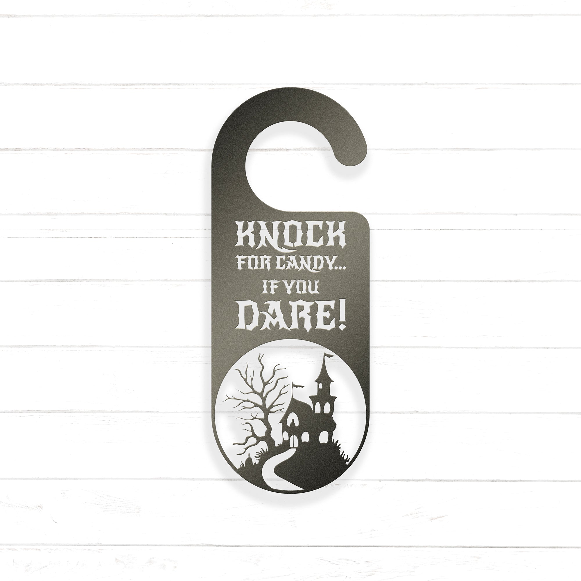 A black and white door hanger with a castle silhouette and the text "KNOCK FOR CANDY... IF YOU DARE!"