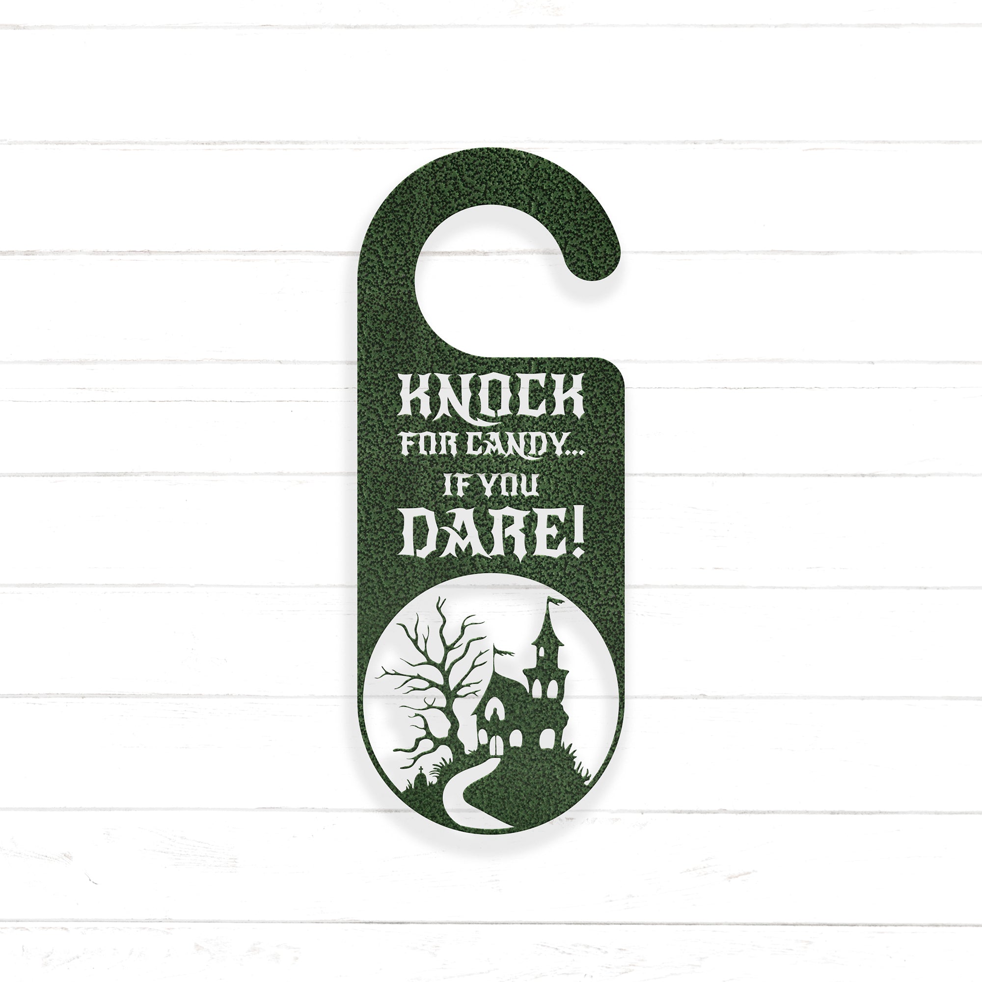 A green door hanger with a castle silhouette and the text "KNOCK FOR CANDY... IF YOU DARE!" printed on it.