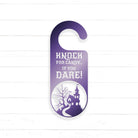 A purple door hanger with a castle silhouette and the text "KNOCK FOR CANDY... IF YOU DARE!" printed on it.