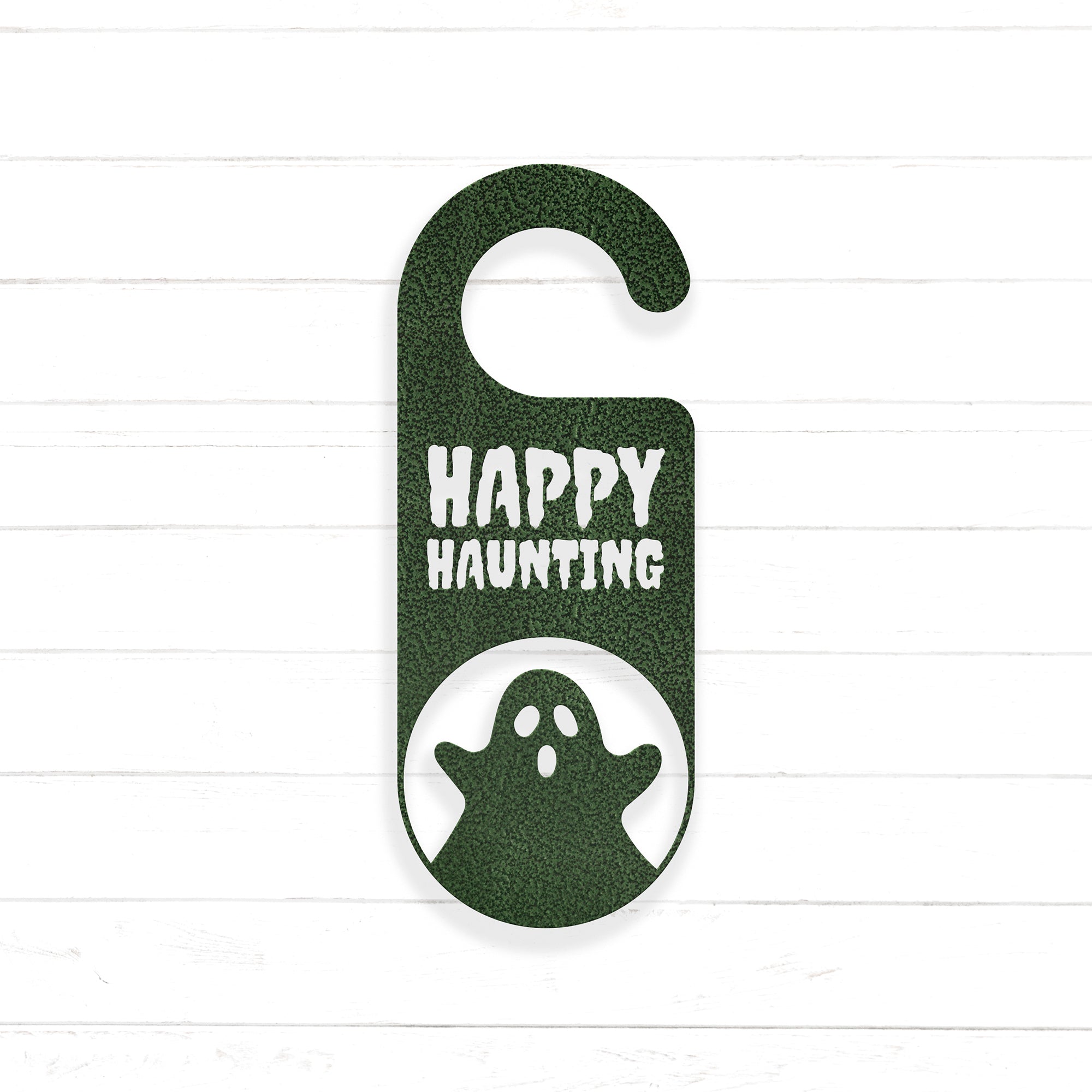 A green hanging door sign with the text "HAPPY HAUNTING" and a ghost silhouette inside a circle.